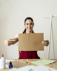 smiling-young-woman-gesturing-while-holding-brown-paper